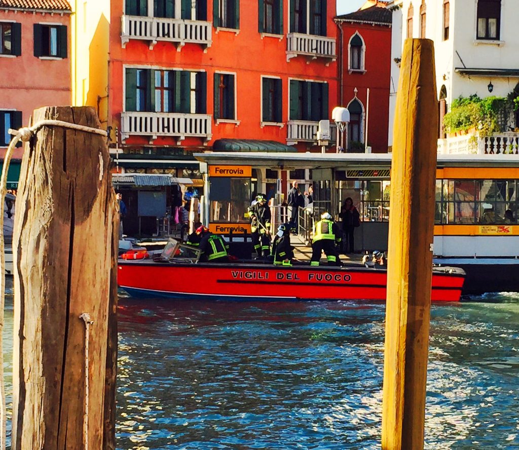 Image shows the fire brigade attending by boat on the canal in Venice